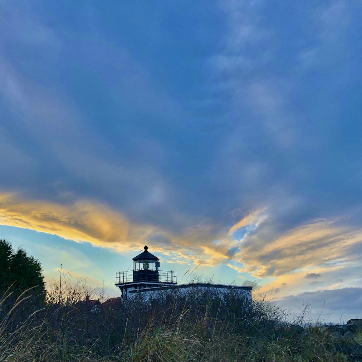 Dramatic clouds over a lighthouse.